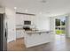 Well-equipped kitchen with stainless appliances, a kitchen island and a sliding glass door with a view to the backyard at 2365 White Tail St, Davenport, FL 33837