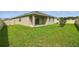 View of the backyard with a well-manicured lawn and covered patio area, perfect for outdoor living at 24401 Sunnys Halo Way, Sorrento, FL 32776