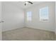 A bright bedroom featuring neutral carpet, ceiling fan, and two windows with bright sunlight at 24401 Sunnys Halo Way, Sorrento, FL 32776