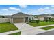 Single-story home featuring well-maintained landscaping, stone accents, and a two-car garage at 24401 Sunnys Halo Way, Sorrento, FL 32776