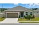 Charming single-story home featuring a stone facade, attached garage, and well-manicured lawn at 24401 Sunnys Halo Way, Sorrento, FL 32776