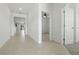 Bright hallway with tile flooring and open doorway leading to bedroom, showcasing modern design at 24401 Sunnys Halo Way, Sorrento, FL 32776