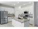Modern kitchen with stainless steel appliances, granite countertops, and white cabinetry for a sleek look at 24401 Sunnys Halo Way, Sorrento, FL 32776