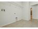 Tiled laundry room with washer hookups, overhead wire rack shelving, and bright natural light at 24401 Sunnys Halo Way, Sorrento, FL 32776
