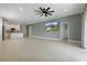 Open-concept living space with tile floors, connecting kitchen island and TV entertainment area at 24401 Sunnys Halo Way, Sorrento, FL 32776
