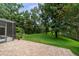Spacious backyard with a brick patio, lush lawn, and mature trees, ideal for outdoor activities at 2592 Westminster Ter, Oviedo, FL 32765