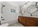 Modern bathroom with dual sinks, wooden cabinets, subway tile, and a shower-tub combination at 2592 Westminster Ter, Oviedo, FL 32765