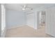 Bedroom with neutral carpet, ceiling fan, closet, and doorway to bathroom at 2592 Westminster Ter, Oviedo, FL 32765