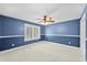 Spacious bedroom with neutral carpet, plantation shutters, and painted blue accent wall at 2592 Westminster Ter, Oviedo, FL 32765