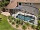 Aerial shot of a private pool area with a screened enclosure, surrounded by landscaped gardens at 2592 Westminster Ter, Oviedo, FL 32765