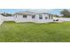 Expansive backyard featuring lush green lawn, white fence, and a cozy patio area perfect for outdoor relaxation at 2926 Carriage Dr, South Daytona, FL 32119