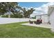 A well-maintained backyard with green grass, a white fence and a cozy patio with comfortable outdoor furniture at 2926 Carriage Dr, South Daytona, FL 32119