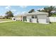 Landscaped single-story home featuring a manicured lawn, white fencing, and mature trees at 2926 Carriage Dr, South Daytona, FL 32119