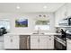 Bright kitchen with stainless steel appliances, white cabinetry, solid surface countertops, and a window view to the office at 2926 Carriage Dr, South Daytona, FL 32119