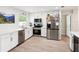 Modern kitchen featuring stainless steel appliances, white cabinets, quartz countertops, and wood-look tile flooring at 2926 Carriage Dr, South Daytona, FL 32119