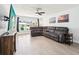 Inviting living room with large windows, tile floors, a modern TV, and a spacious gray sectional at 2926 Carriage Dr, South Daytona, FL 32119