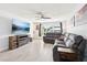 Bright living room with a ceiling fan, tile floors, a large TV, and comfortable gray sectional sofa at 2926 Carriage Dr, South Daytona, FL 32119