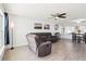 Spacious living room with a ceiling fan, tile flooring, comfortable gray sofa, and natural light at 2926 Carriage Dr, South Daytona, FL 32119