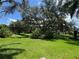 Expansive backyard with mature trees providing shade, perfect for outdoor activities and relaxation at 3807 Plantation Blvd, Leesburg, FL 34748