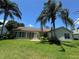 Well-maintained home featuring an immaculate lawn, complemented by lush tropical landscaping and mature palm trees at 3807 Plantation Blvd, Leesburg, FL 34748
