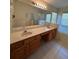 Bathroom featuring double vanity, framed mirror, walk-in shower, and a soaking tub at 3807 Plantation Blvd, Leesburg, FL 34748
