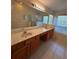 Primary bathroom with dual sinks, large mirror, shower, and soaking tub at 3807 Plantation Blvd, Leesburg, FL 34748