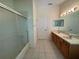 Bathroom featuring dual sinks, large mirror, shower with sliding glass doors and a white door at 3807 Plantation Blvd, Leesburg, FL 34748