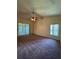 Roomy bedroom featuring carpet, ceiling fan, and sliding glass door access to the patio at 3807 Plantation Blvd, Leesburg, FL 34748