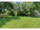 Large, grassy backyard enclosed by a wooden fence and shaded by mature trees, creating a private outdoor space at 4106 Alverado St, Orlando, FL 32812