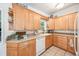 Well-lit kitchen with wooden cabinetry, updated appliances, and ample counter space at 4106 Alverado St, Orlando, FL 32812