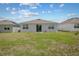 Spacious backyard with lush green grass leading to a patio and the rear of the house at 4266 Wrangler Ln, Mascotte, FL 34753