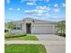 Beautiful one-story home featuring well-manicured lawn, gray shutters and a two car garage with paved driveway at 4266 Wrangler Ln, Mascotte, FL 34753