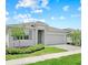 Beautiful one-story home featuring well-manicured lawn, gray shutters and a two car garage with paved driveway at 4266 Wrangler Ln, Mascotte, FL 34753