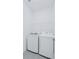 Convenient laundry room with washer, dryer, and wire shelving for storage at 4266 Wrangler Ln, Mascotte, FL 34753