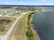 Aerial view of homes along a lakeside with new development and scenic backdrop, showing a picturesque setting at 4343 Juliana Lake Dr, Auburndale, FL 33823