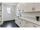 Well-lit laundry room with white cabinets, black hardware, dark floors, and a window for natural light at 4343 Juliana Lake Dr, Auburndale, FL 33823