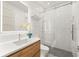 Modern bathroom featuring a frameless glass shower, wood vanity with white countertop, and orchid decoration at 4934 Legacy Oaks Dr, Orlando, FL 32839