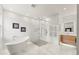 Bright bathroom featuring a modern soaking tub, glass shower and sleek wood vanity with white marble countertops at 4934 Legacy Oaks Dr, Orlando, FL 32839