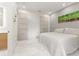 Bright bedroom featuring a queen bed, minimalist decor, and ensuite bathroom access at 4934 Legacy Oaks Dr, Orlando, FL 32839