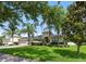 A charming home features a lush green lawn, mature trees, and a classic architectural design at 4934 Legacy Oaks Dr, Orlando, FL 32839