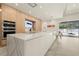 Modern kitchen with stainless steel appliances, oversized waterfall island, and views of outdoor pool at 4934 Legacy Oaks Dr, Orlando, FL 32839