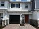 Charming townhome with a brick driveway, black garage door, and a welcoming orange front door at 5101 Prairie Preserve Run, St Cloud, FL 34772
