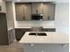 Modern kitchen featuring gray cabinets, stainless steel microwave, subway tile backsplash, and an island with a sink at 5101 Prairie Preserve Run, St Cloud, FL 34772
