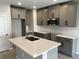 Modern kitchen with gray cabinets, stainless steel microwave, subway tile backsplash, and a large island with a sink at 5101 Prairie Preserve Run, St Cloud, FL 34772