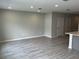Bright living room with gray wood-look flooring and neutral paint at 5101 Prairie Preserve Run, St Cloud, FL 34772