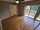 Bedroom featuring hardwood floors, ceiling fan, closet, and sliding glass door to balcony at 5288 Cypress Ct # 439, Orlando, FL 32811