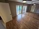 Spacious bedroom with hardwood floors, ceiling fan, mirrored closet, and pond view at 5288 Cypress Ct # 439, Orlando, FL 32811