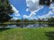 Scenic view of the community pond with lush green lawn on a sunny day at 5288 Cypress Ct # 439, Orlando, FL 32811