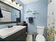 Well-lit bathroom with a modern sink, toilet, and a shower with a decorative curtain at 5365 Rocking Horse Pl, Oviedo, FL 32765
