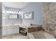 Bright bathroom with granite countertops, vanity, soaking tub, and stone accent wall at 5365 Rocking Horse Pl, Oviedo, FL 32765